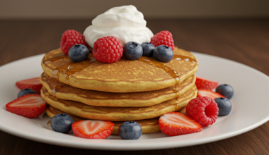 Stack of golden fluffy pancakes with syrup.